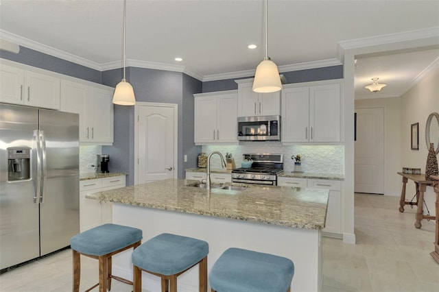 kitchen with a center island with sink, sink, white cabinetry, hanging light fixtures, and appliances with stainless steel finishes