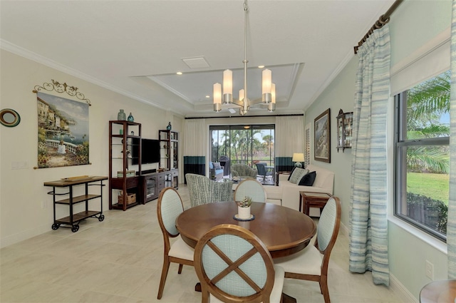 dining space with crown molding, a raised ceiling, and a notable chandelier