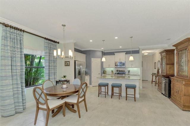 dining space featuring an inviting chandelier, ornamental molding, and sink