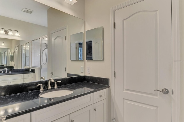 bathroom featuring walk in shower and vanity