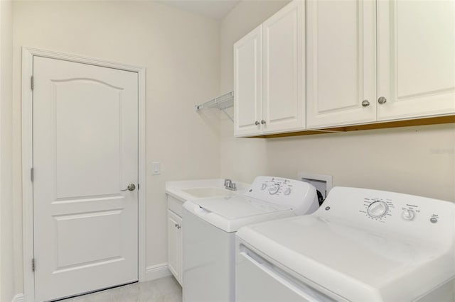 washroom with cabinets, sink, and washing machine and dryer