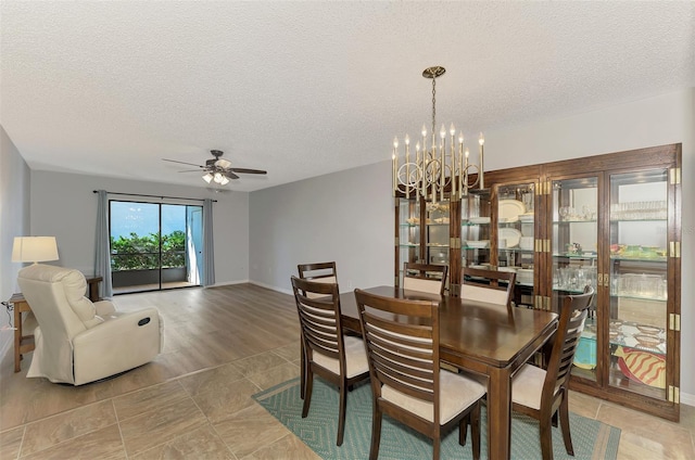 dining space with ceiling fan with notable chandelier and a textured ceiling