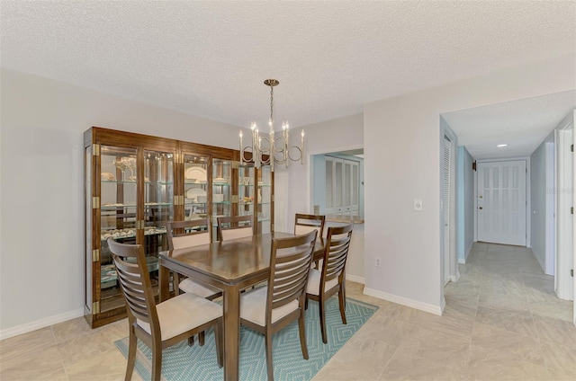 dining area with a textured ceiling and a chandelier