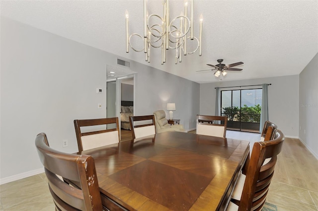 dining area with light tile patterned flooring, ceiling fan with notable chandelier, and a textured ceiling