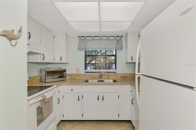 kitchen featuring sink, white cabinets, and white appliances