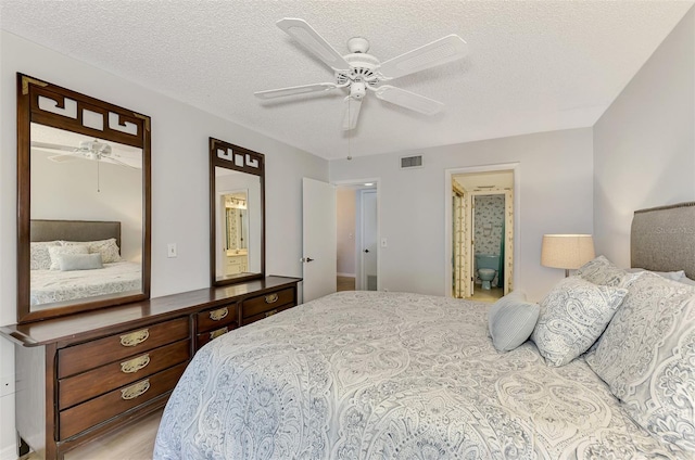 bedroom featuring connected bathroom, ceiling fan, light hardwood / wood-style floors, and a textured ceiling