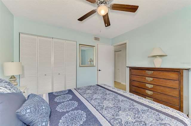 bedroom with ceiling fan, a textured ceiling, and a closet