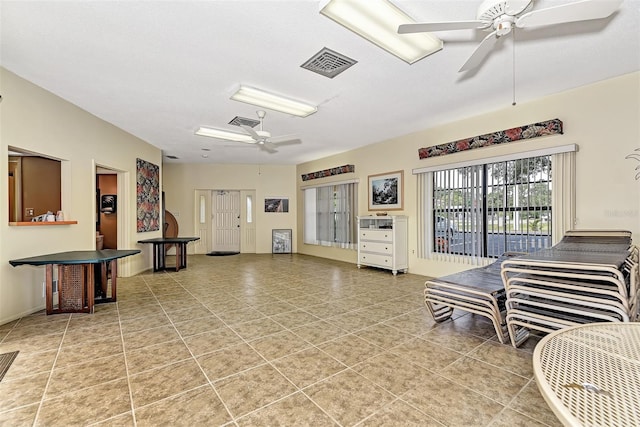 tiled living room featuring ceiling fan and a textured ceiling