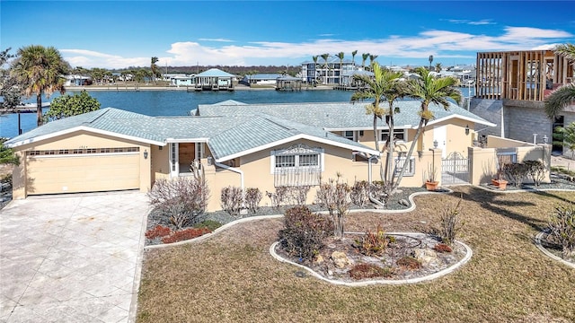 view of front of house featuring a water view, a garage, and a front lawn