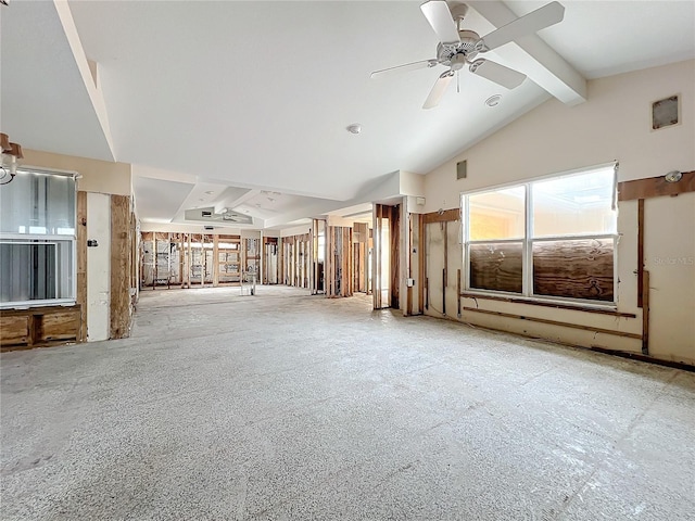 unfurnished living room featuring ceiling fan and vaulted ceiling with beams