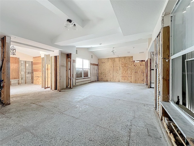 carpeted empty room with wooden walls and lofted ceiling with beams