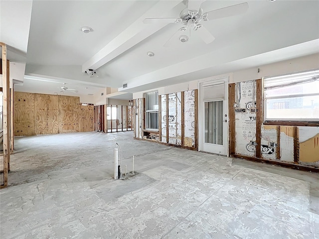 empty room with ceiling fan, beamed ceiling, and wooden walls