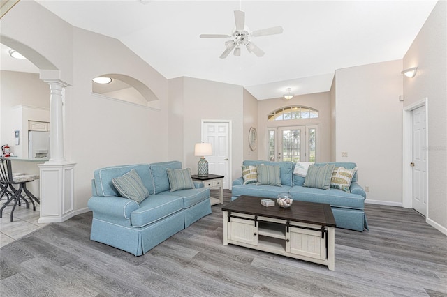 living room featuring vaulted ceiling, light hardwood / wood-style floors, ceiling fan, and ornate columns