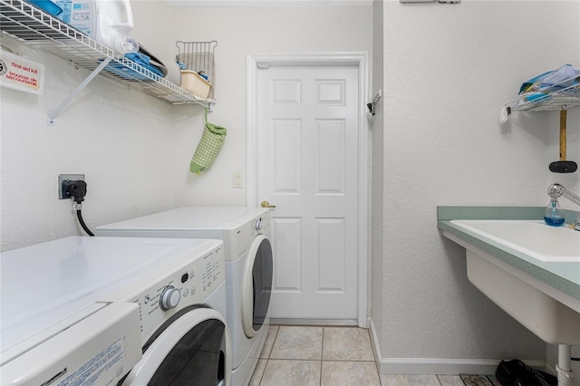 laundry room featuring light tile patterned floors, sink, and washing machine and clothes dryer