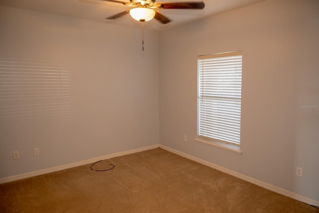 carpeted spare room with ceiling fan