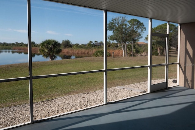 unfurnished sunroom featuring a water view