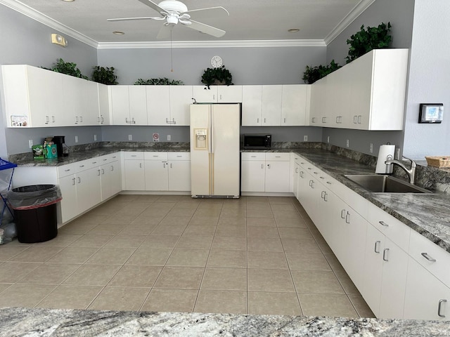 kitchen featuring ornamental molding, white refrigerator with ice dispenser, sink, and white cabinets