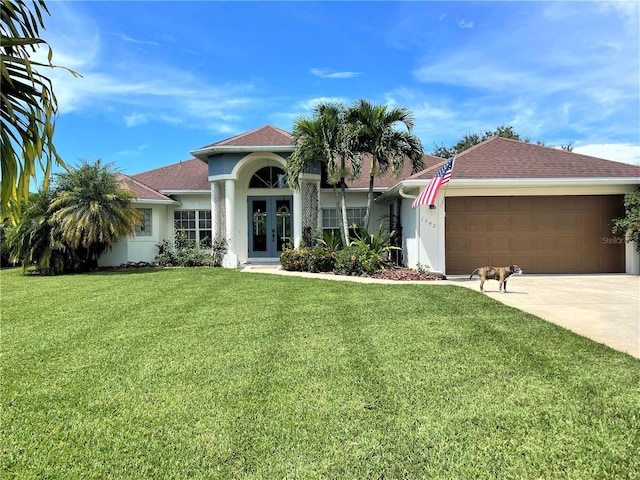 view of front of home featuring a garage, a front lawn, and french doors