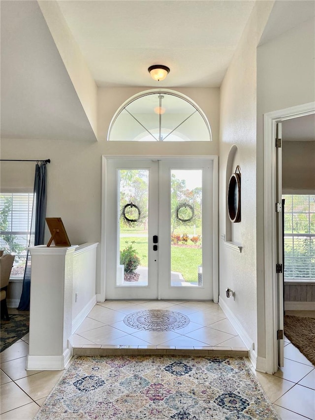 tiled foyer entrance featuring french doors and a healthy amount of sunlight