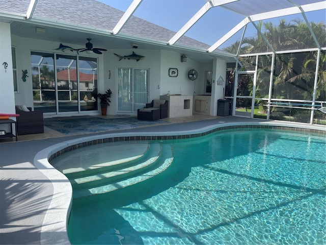 view of swimming pool with a patio area, ceiling fan, and glass enclosure