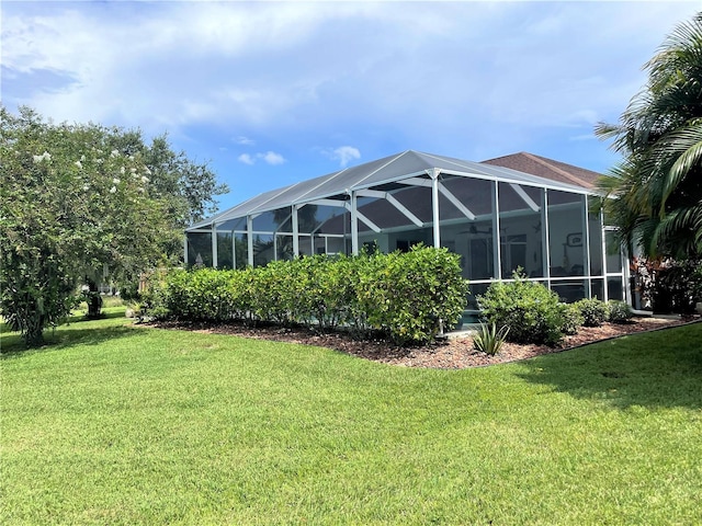 rear view of property featuring glass enclosure and a lawn