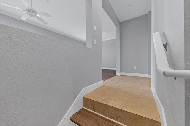 staircase featuring ceiling fan and tile patterned floors