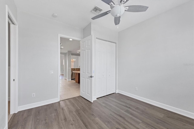 unfurnished bedroom featuring wood-type flooring, a closet, and ceiling fan