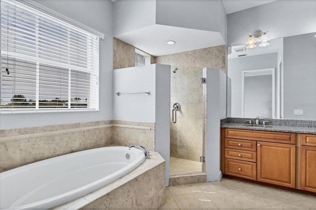 bathroom featuring independent shower and bath, vanity, and tile patterned floors