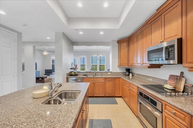 10360 Longshore Rd Unit 66, Placida, FL 33946 - kitchen featuring appliances with stainless steel finishes, light stone countertops, brown cabinetry, light tile patterned floors, and recessed lighting