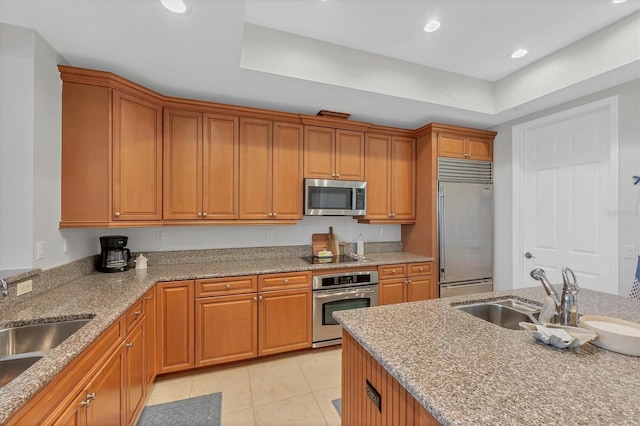 10360 Longshore Rd Unit 66, Placida, FL 33946 - kitchen with stainless steel appliances, light tile patterned flooring, light stone counters, brown cabinets, and recessed lighting