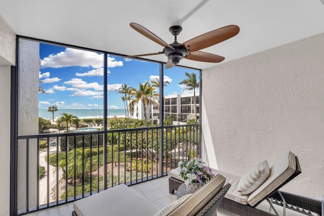 sunroom / solarium with ceiling fan, a wealth of natural light, and a water view