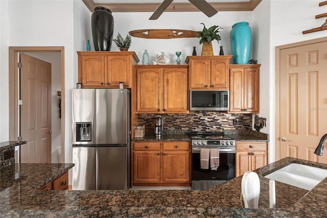 kitchen with ceiling fan, appliances with stainless steel finishes, dark stone counters, and tasteful backsplash