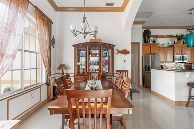 tiled dining area with ceiling fan with notable chandelier, ornamental molding, and a healthy amount of sunlight