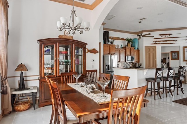 tiled dining space featuring ceiling fan with notable chandelier and crown molding