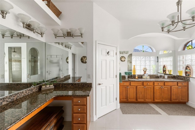 bathroom featuring vanity, a shower with shower door, a chandelier, and tile patterned floors