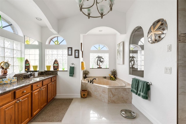 bathroom with a relaxing tiled tub, tile patterned floors, vanity, and an inviting chandelier