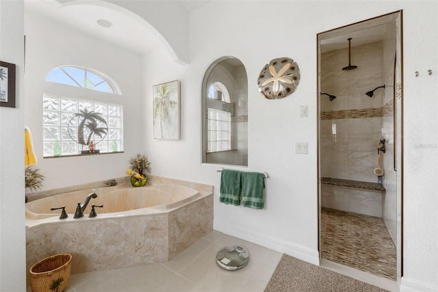 bathroom with tile patterned flooring and shower with separate bathtub