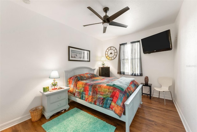 bedroom with dark hardwood / wood-style floors and ceiling fan