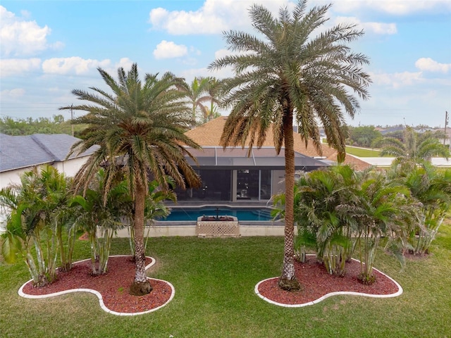 view of swimming pool with glass enclosure and a lawn