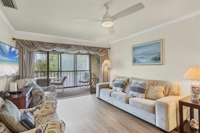 living room featuring ceiling fan, ornamental molding, and wood-type flooring