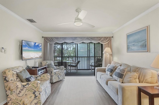 living room with hardwood / wood-style floors, crown molding, and ceiling fan