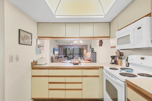 kitchen featuring cream cabinets and white appliances