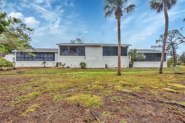 ranch-style home with a sunroom and a front lawn