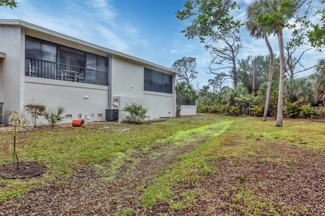 view of home's exterior featuring central AC unit and a lawn