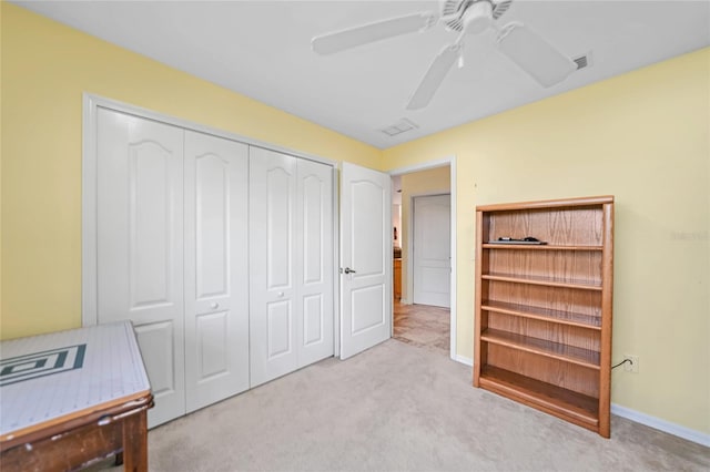 bedroom featuring a closet, light carpet, and ceiling fan