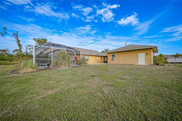 rear view of house featuring a lanai and a lawn