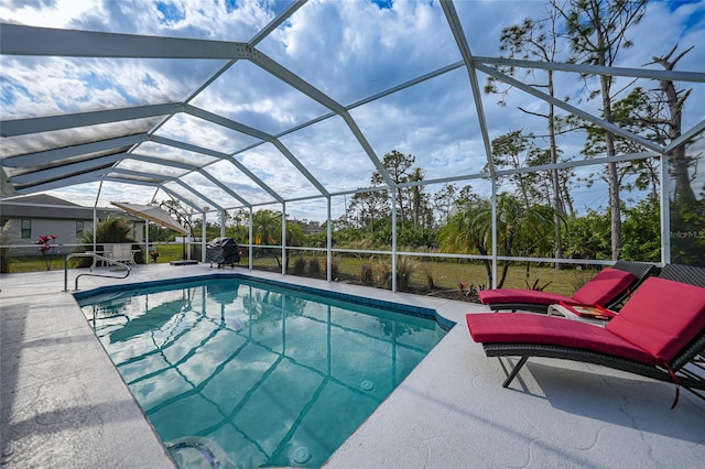 view of pool with glass enclosure and a patio area