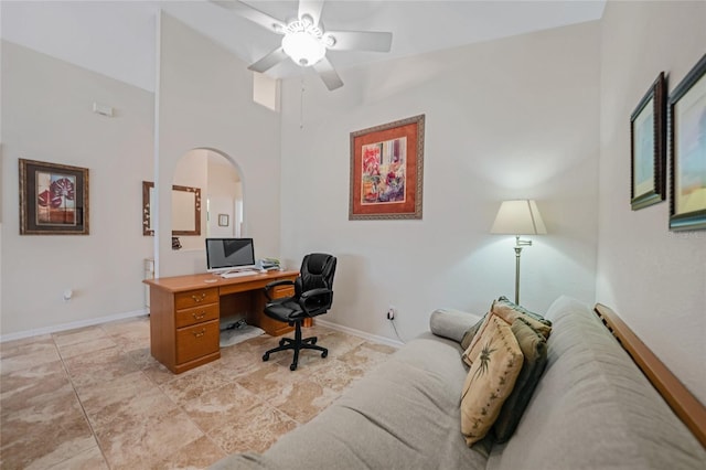 tiled office with ceiling fan and a towering ceiling