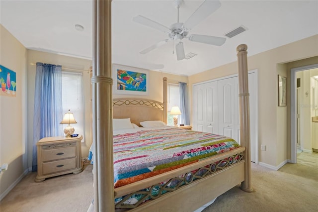 carpeted bedroom featuring ceiling fan, ensuite bath, and a closet