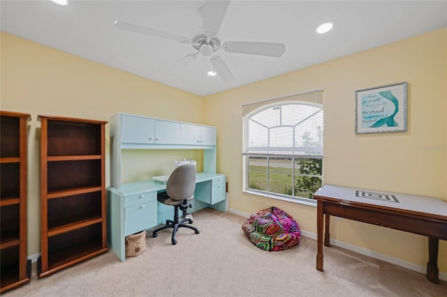 carpeted office space with ceiling fan